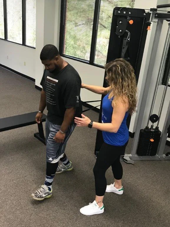 Trainer guiding a client through corrective movement